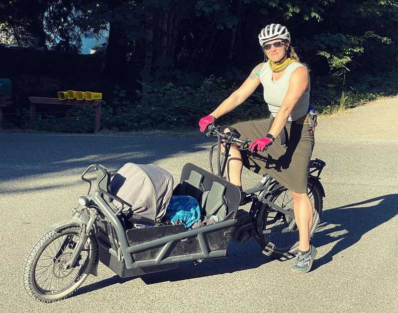 Me on my Riese and Mueller cargo bike, with a box containing a baby car seat in the front